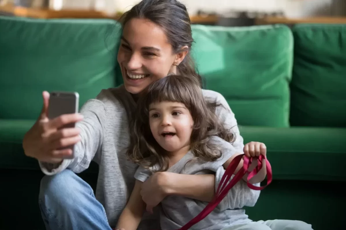 Matka s dítětem natáčí video na telefon