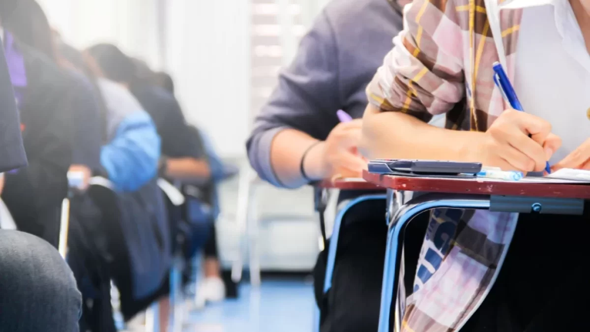 Studenti píšou test ve školní lavici