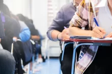 Studenti píšou test ve školní lavici