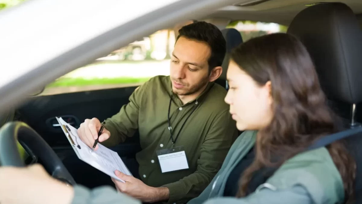 Instruktor, autoškoly který sedí v autě se studentkou