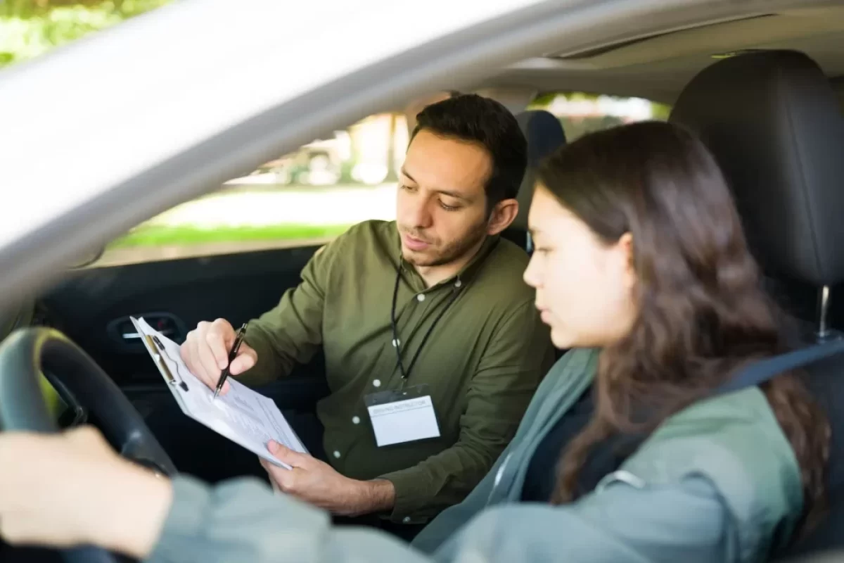 Instruktor, autoškoly který sedí v autě se studentkou