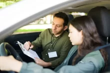 Instruktor, autoškoly který sedí v autě se studentkou