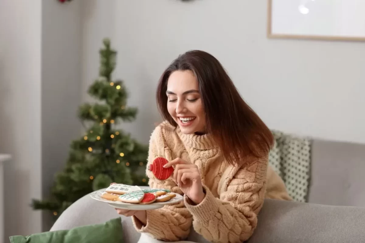 Žena si pochutnává na vánočním cukroví