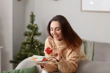 Žena si pochutnává na vánočním cukroví