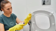 Žena čistí toaletu.