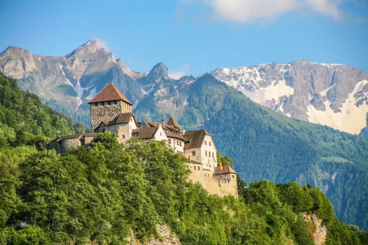 Výhled na lichtenštejnský hrad a Alpy v pozadí