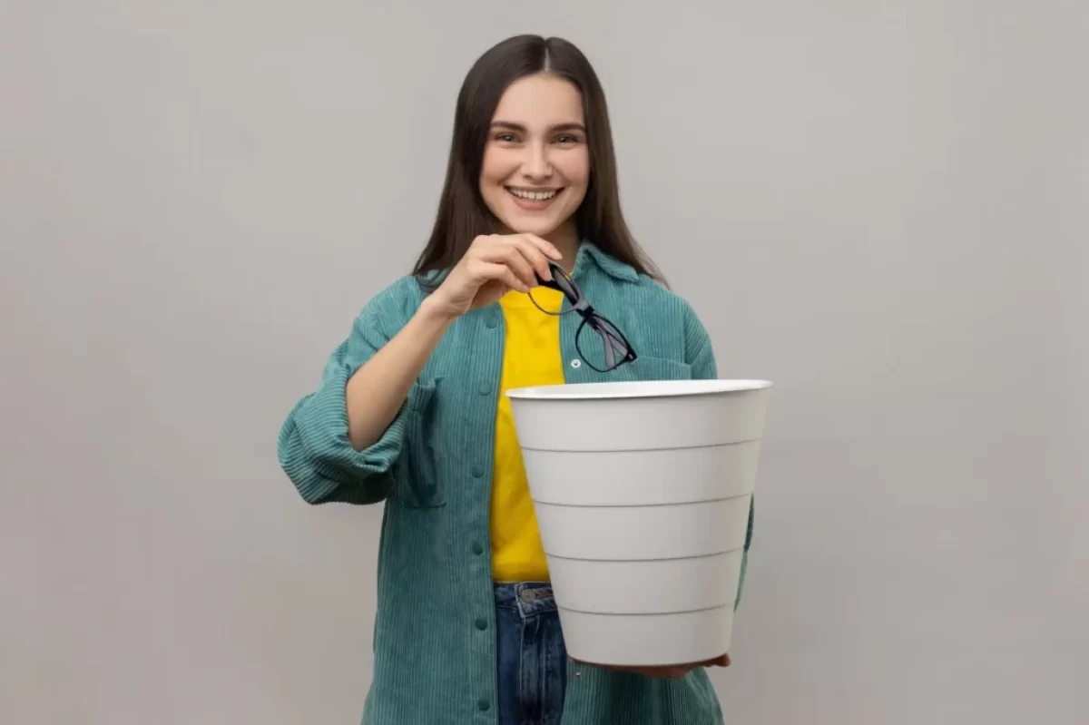 Žena hází dioptrické brýle do koše
