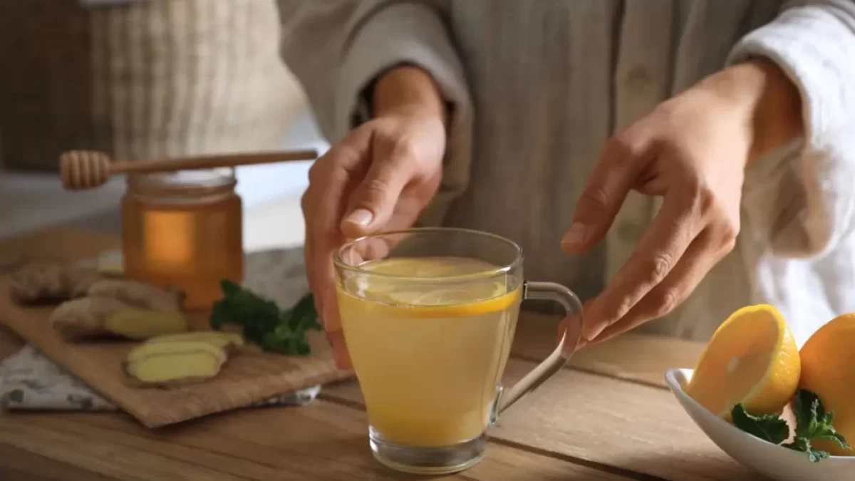 Žena připravuje horký nápoj ze zázvoru a citronu