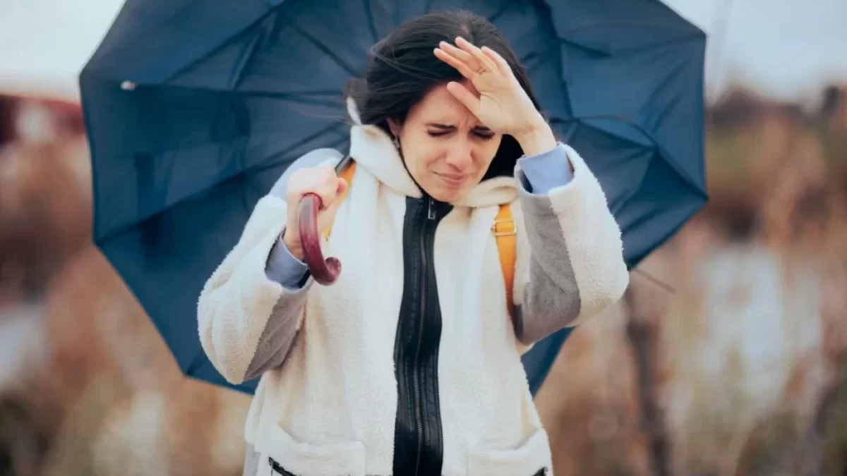 Žena jde s deštníkem proti větru