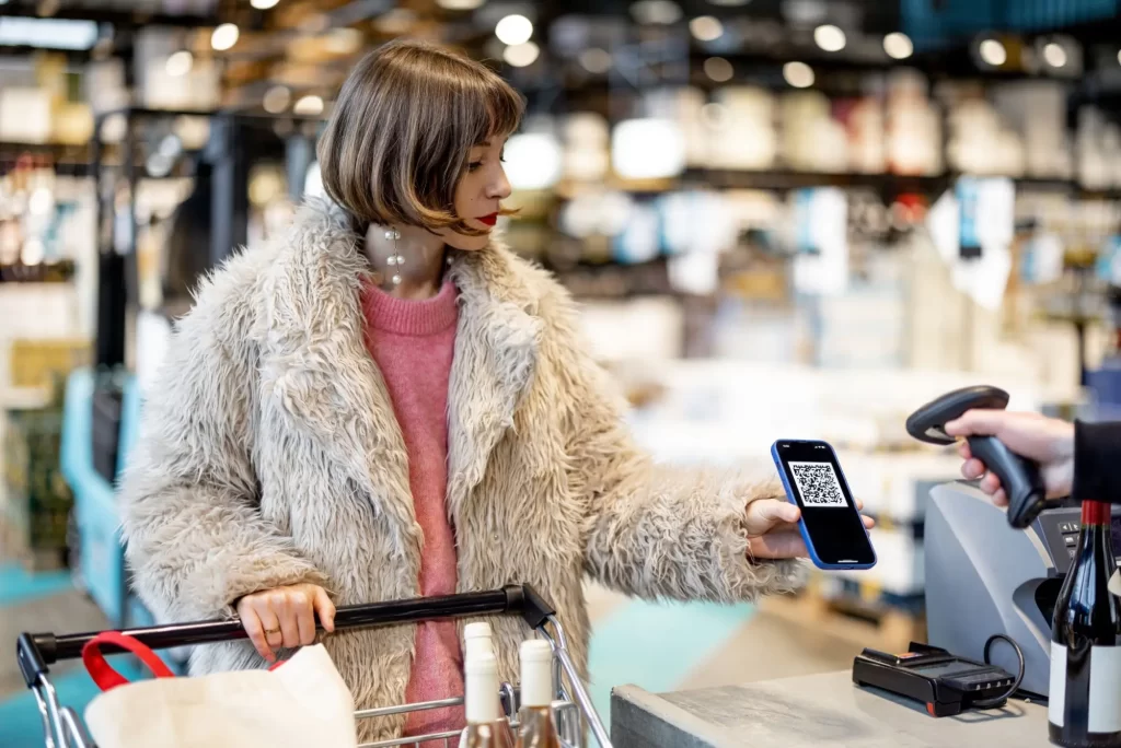 Žena, která u pokladny uplatňuje věrnostní program pomocí QR kódu