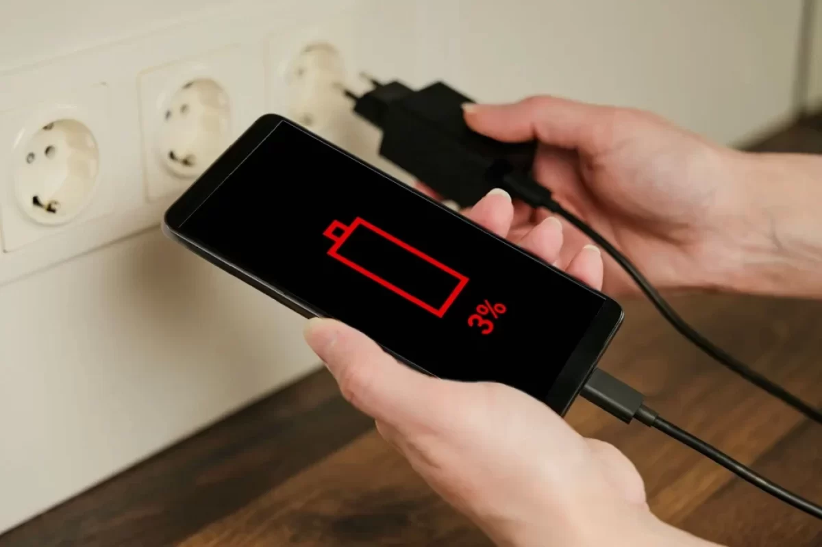 Žena připojuje telefon k nabíječce