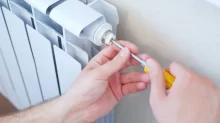 Muž reguluje ventil u topení