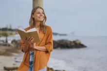 žena si s úsměvem čte knihu