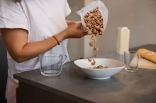 Žena sype do misky cereálie