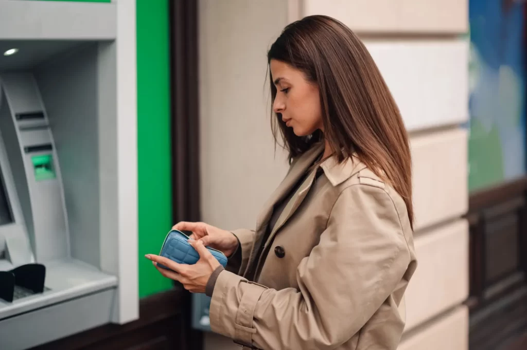 žena vybírá peníze z automatu