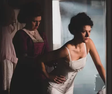 Žena se nechá navlékat do korzetu