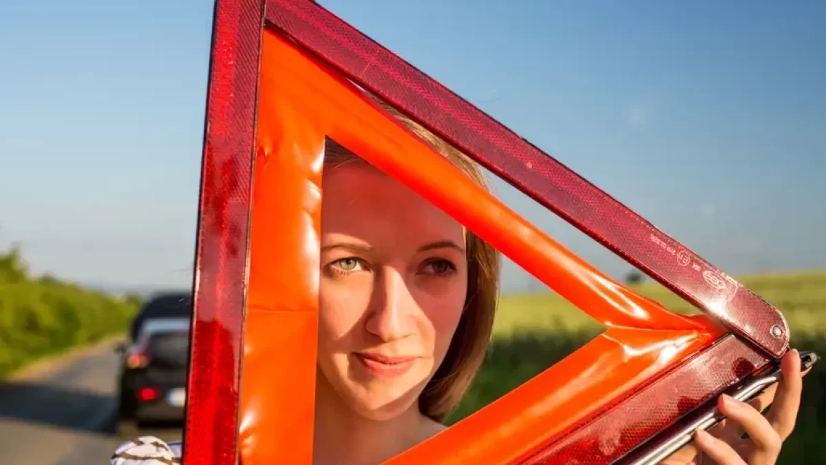 Žena drží výstražný trojúhelník