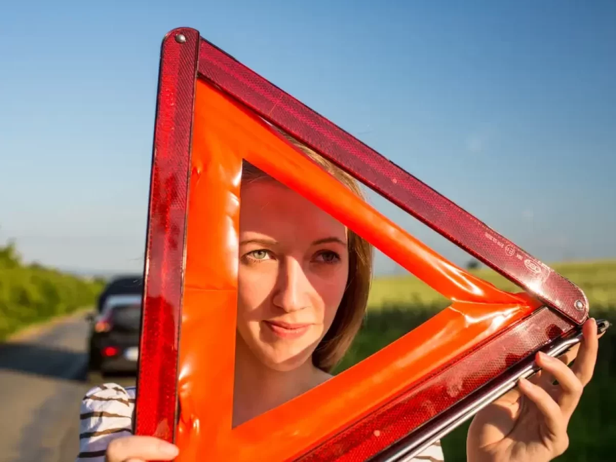 Žena drží výstražný trojúhelník