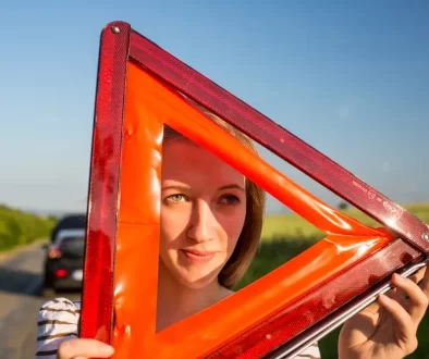 Žena drží výstražný trojúhelník