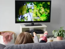 Žena sedí na gauči u televize