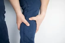 člověk drží nohu