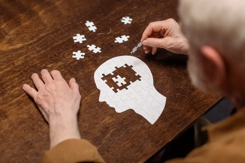 muž s demencí skládá puzzle