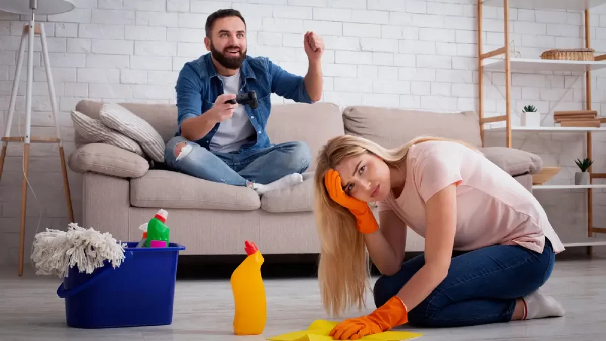 žena uklízí a muž hraje hru