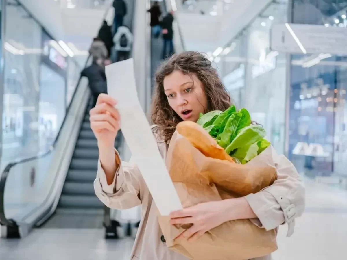 Zděšená žena čte ceny na lístku z pokladny