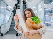 Zděšená žena čte ceny na lístku z pokladny