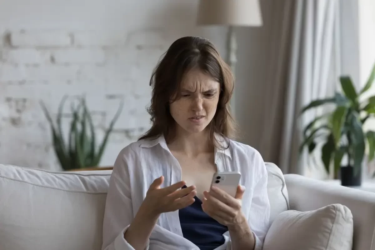 Naštvaná žena se dívá na mobil