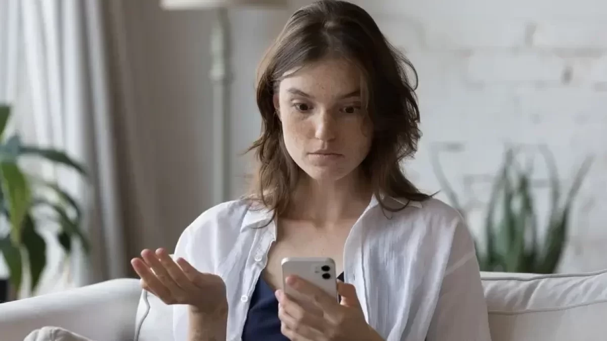 zmatená žena kouká na smartphone