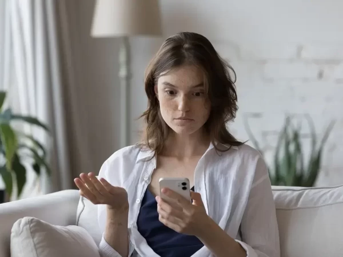 zmatená žena kouká na smartphone