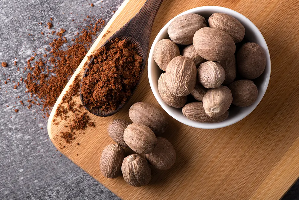 Muškátový oříšek podporuje chuť k jídlu, stimuluje produkci trávicích šťáv a působí proti křečím v břiše a nadýmání. - Techsvět muškátový oříšek v misce
