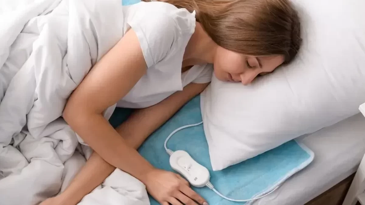 Žena spí v posteli s nahřívací podložkou