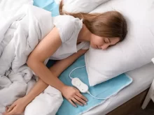 Žena spí v posteli s nahřívací podložkou