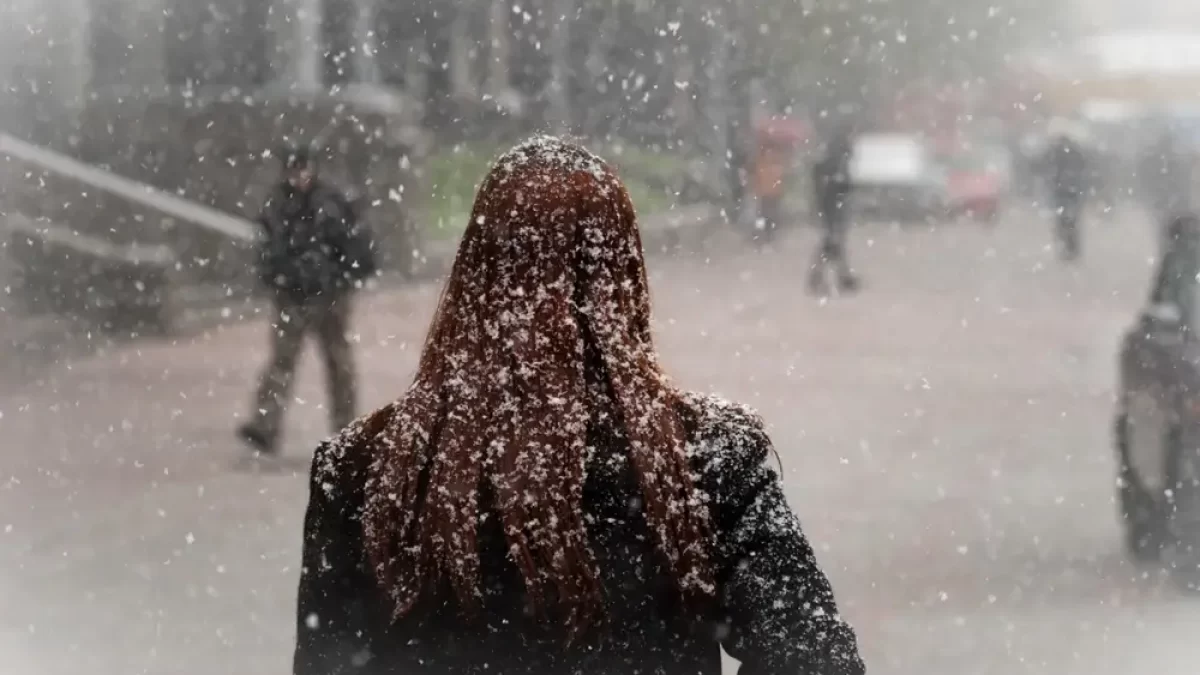 Žena procházející ulicí, když sněží