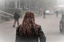 Žena procházející ulicí, když sněží
