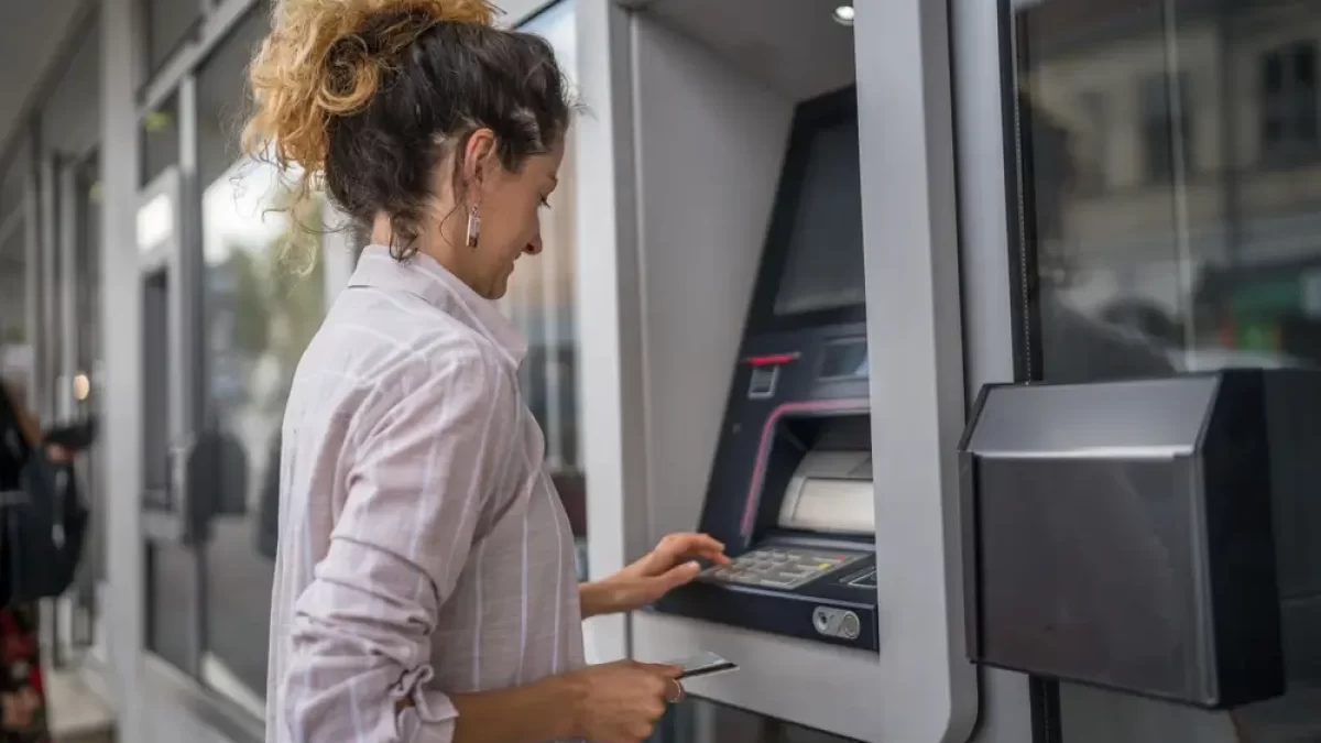 Žena vybírá peníze z bankomatu