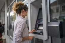Žena vybírá peníze z bankomatu