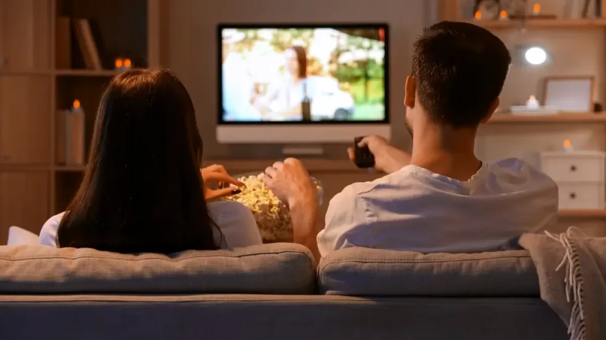 Mladý pár koukající se na televizi