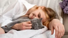 žena spí v posteli s kočkou