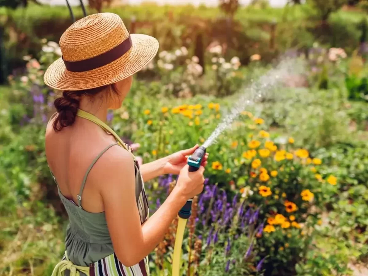 Žena kropí zahradu vodou