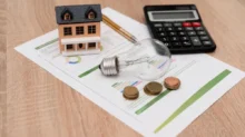 kalkulačka, žárovna a mince na stole
