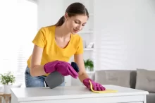 žena utírá nábytek hadříkem