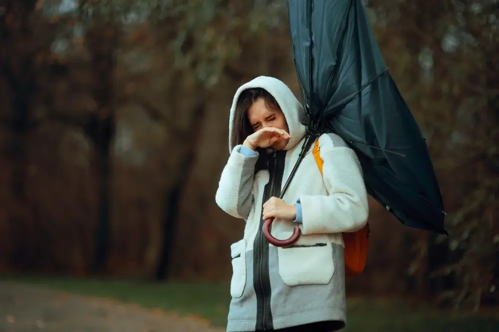 žena v dešti s rozbitým deštníkem