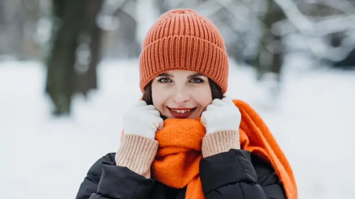 žena v zimě s oranžovou šálou a čepicí