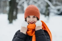 žena v zimě s oranžovou šálou a čepicí