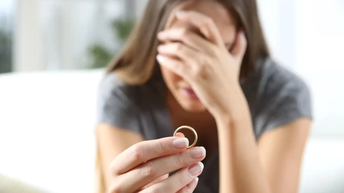 nešťastná žena se snubním prstýnkem v ruce