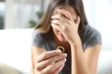 nešťastná žena se snubním prstýnkem v ruce