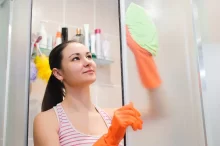 žena umývá sprchový kout